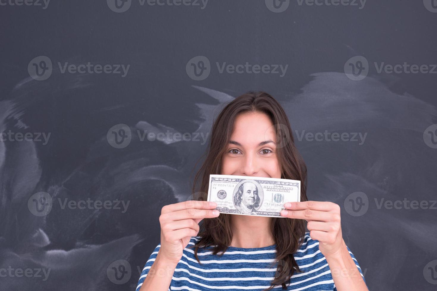 mujer sosteniendo un billete frente a un tablero de dibujo de tiza foto