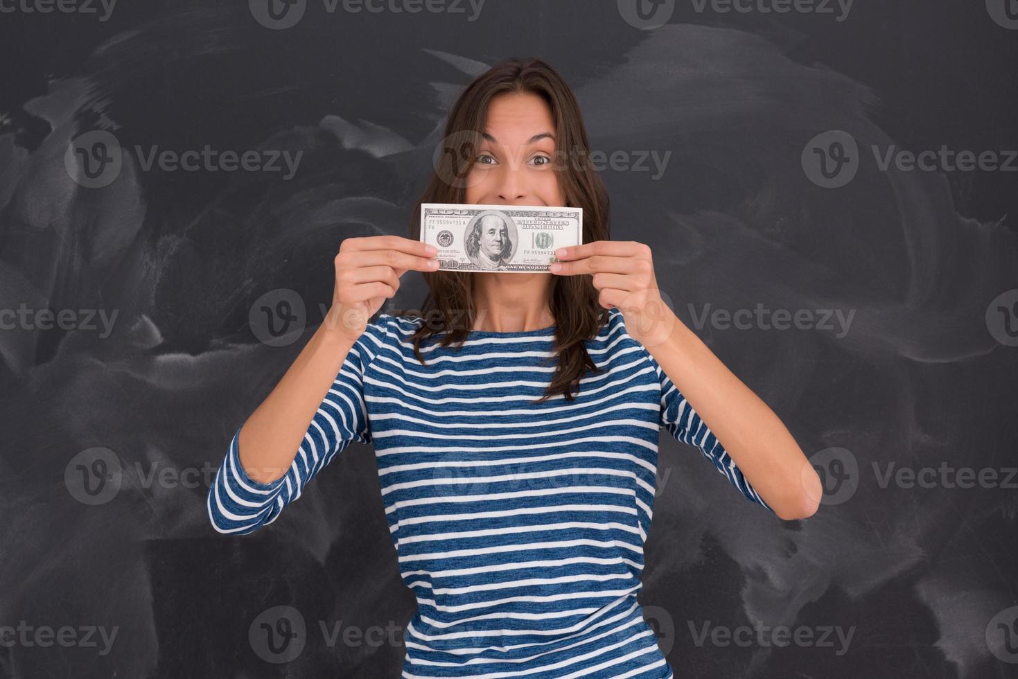 mujer sosteniendo un billete frente a un tablero de dibujo de tiza foto