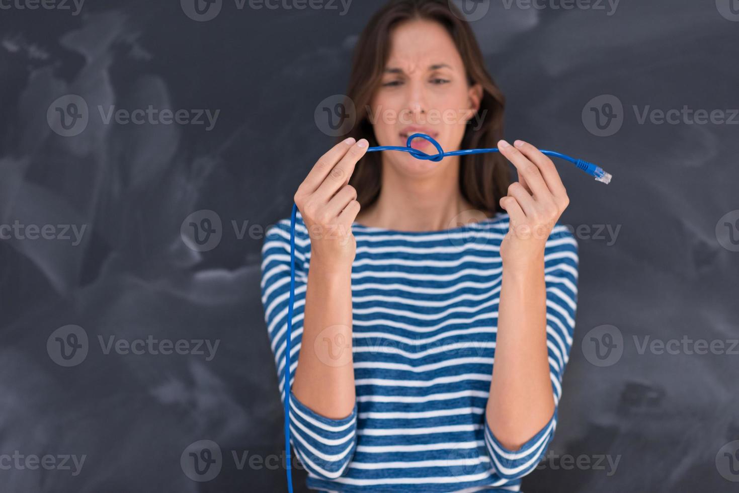 woman holding a internet cable in front of chalk drawing board photo