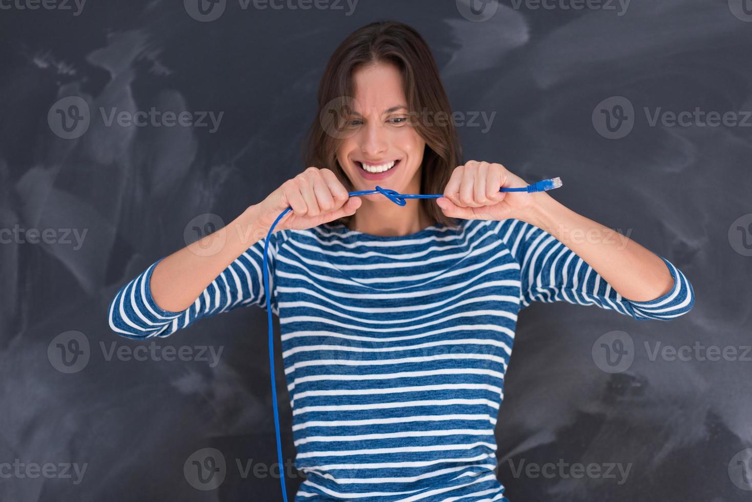 mujer sosteniendo un cable de internet frente a un tablero de dibujo de tiza foto