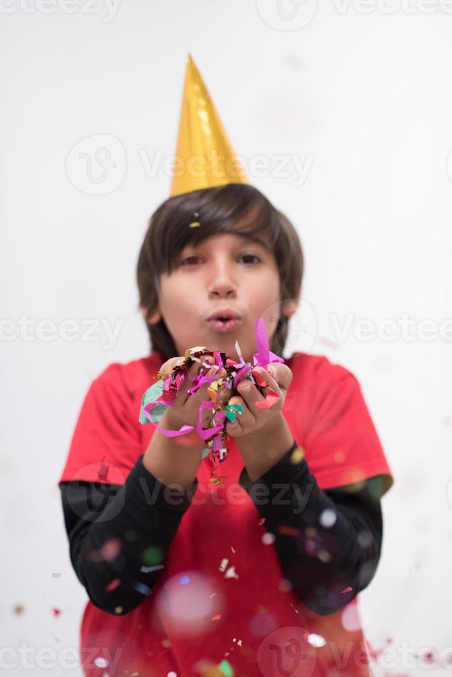 niño soplando confeti foto