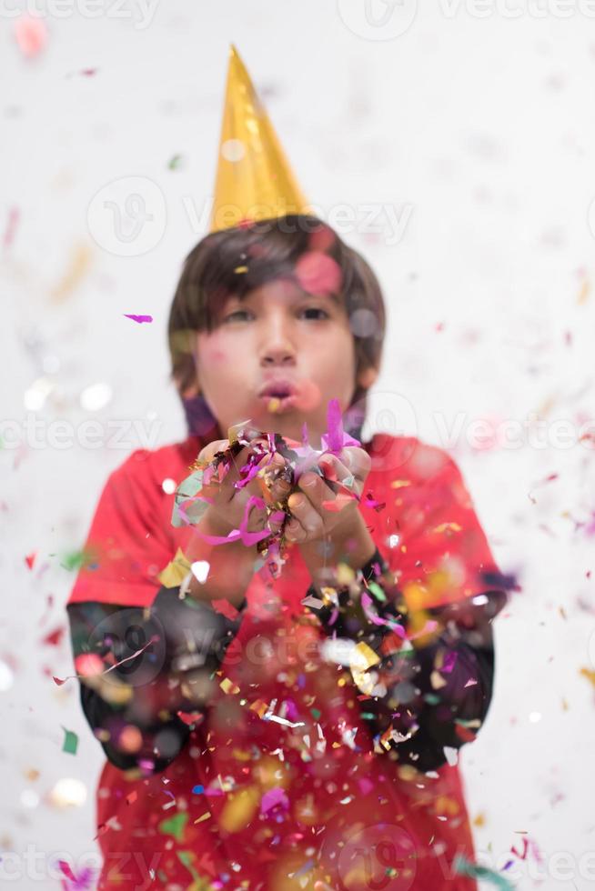 niño soplando confeti foto