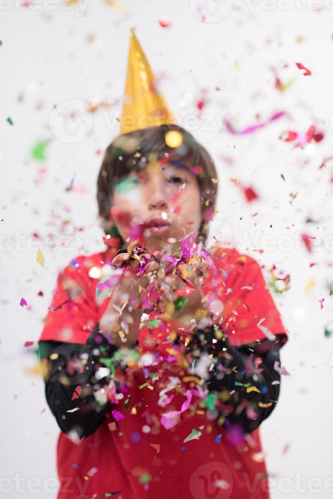 niño soplando confeti foto