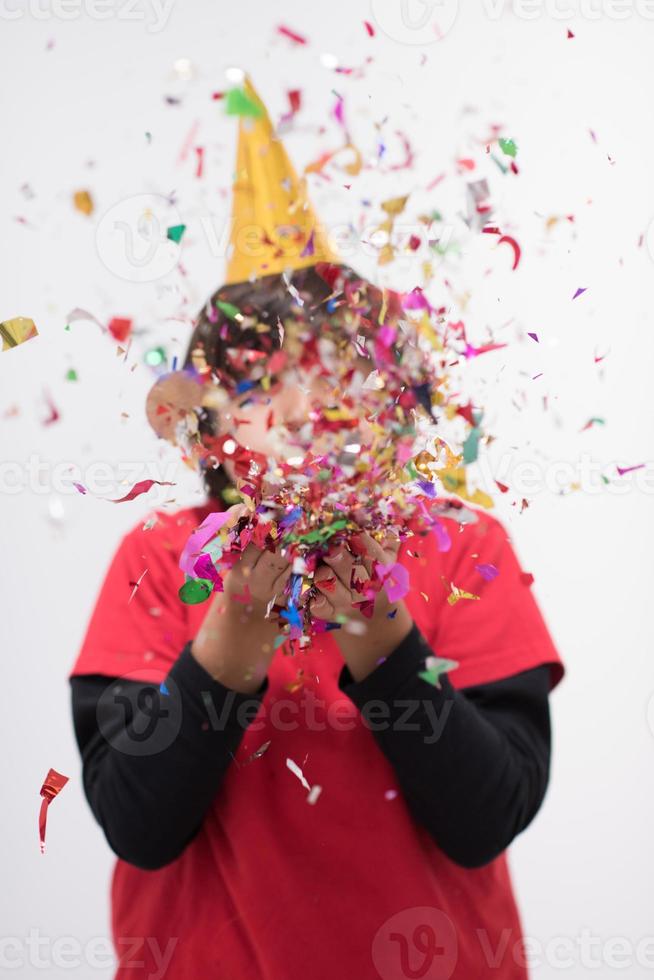 niño soplando confeti foto