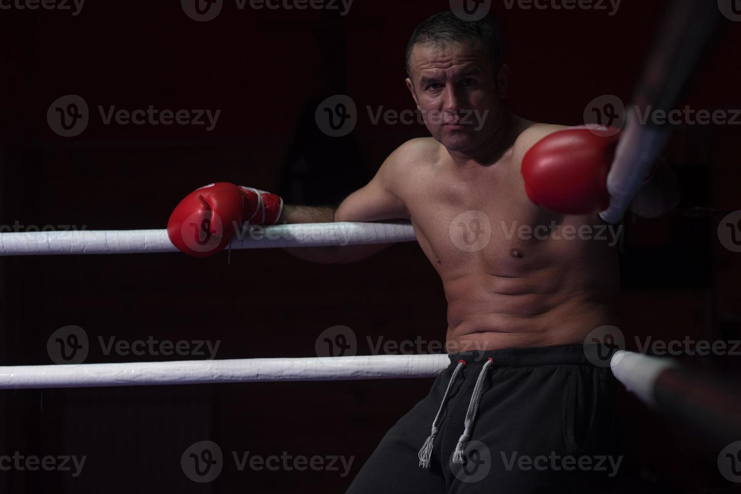 kick boxer resting on the ropes in the corner photo