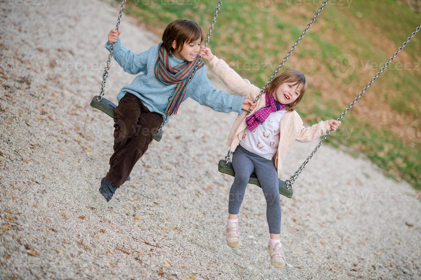 los niños se balancean en el parque foto