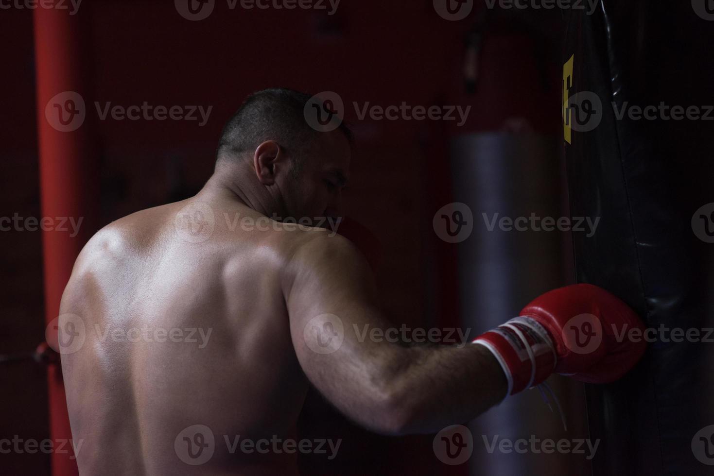 kick boxer training on a punching bag photo