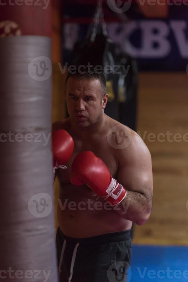 kick boxer training on a punching bag photo