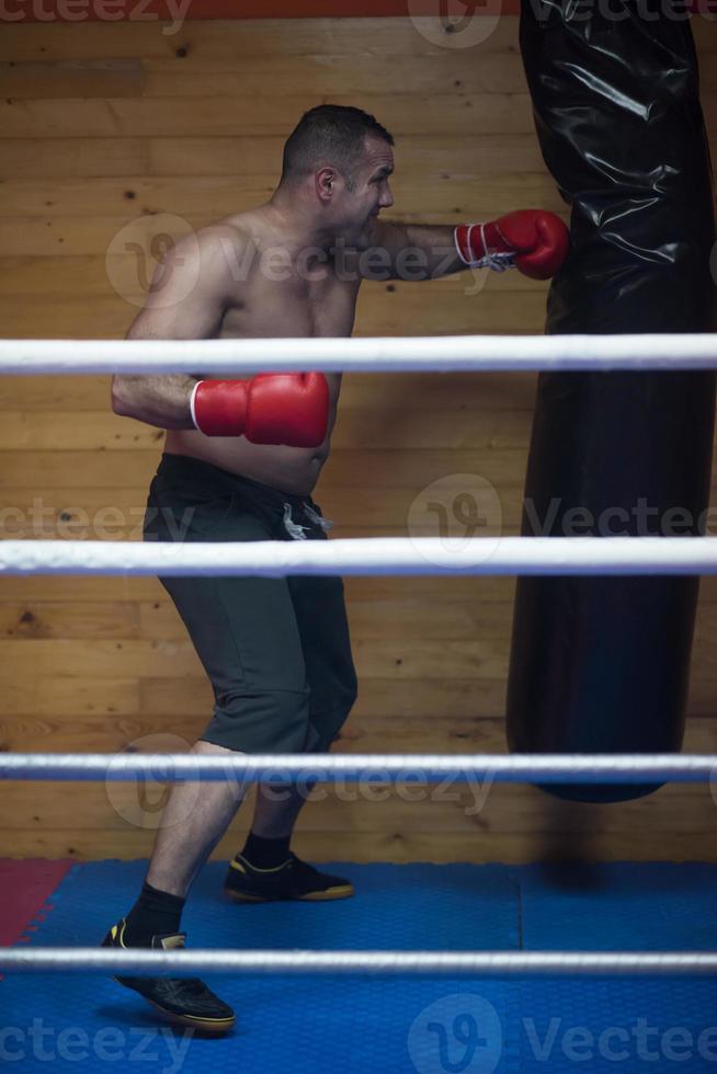 kick boxer training on a punching bag photo