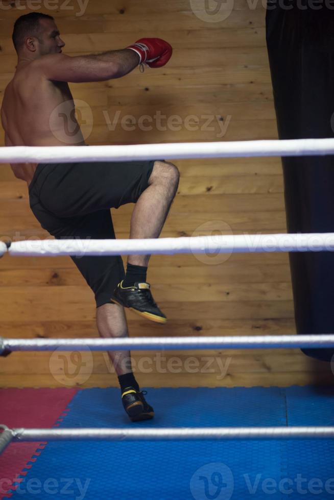 kick boxer entrenando en un saco de boxeo foto