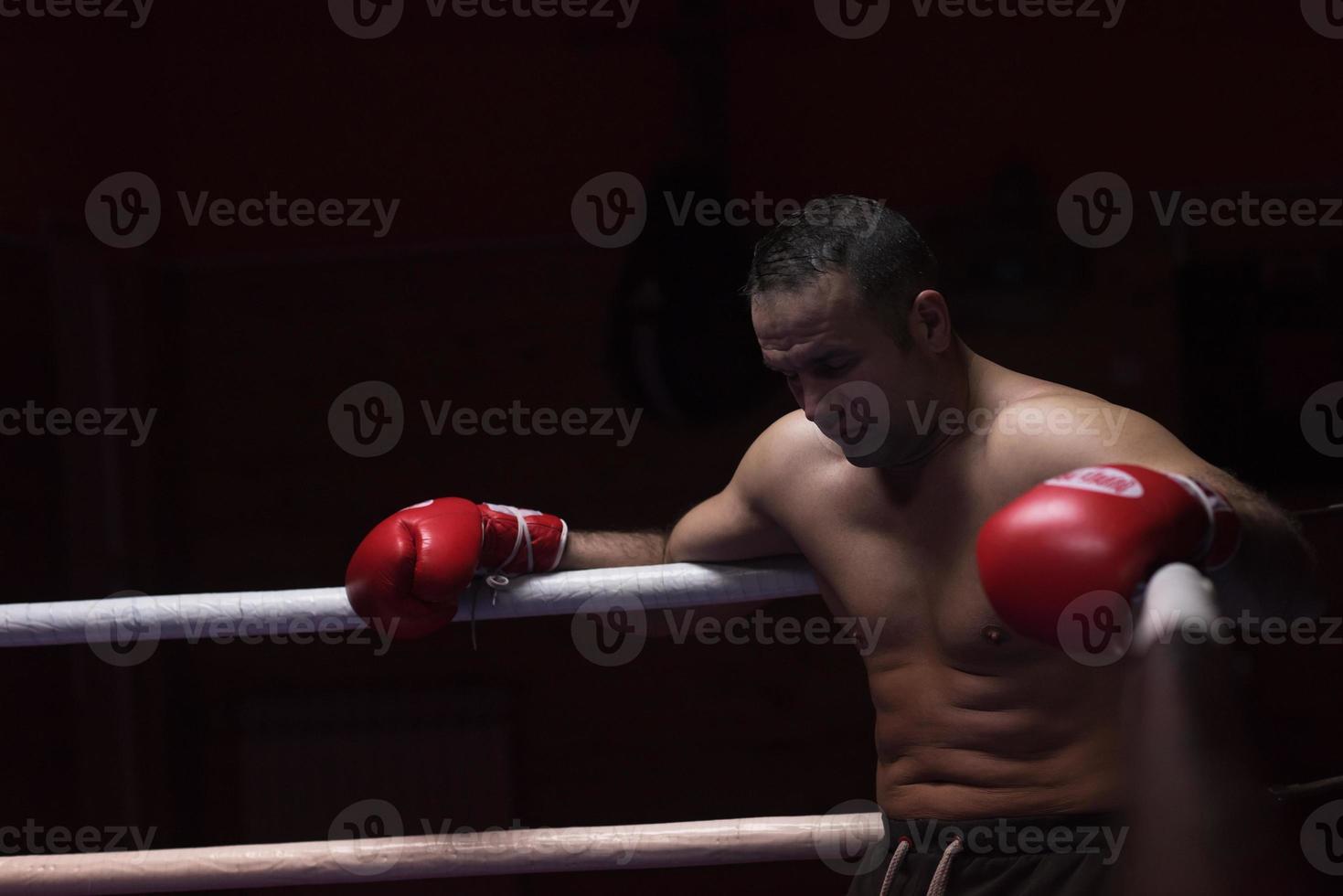 kick boxer descansando sobre las cuerdas en la esquina foto