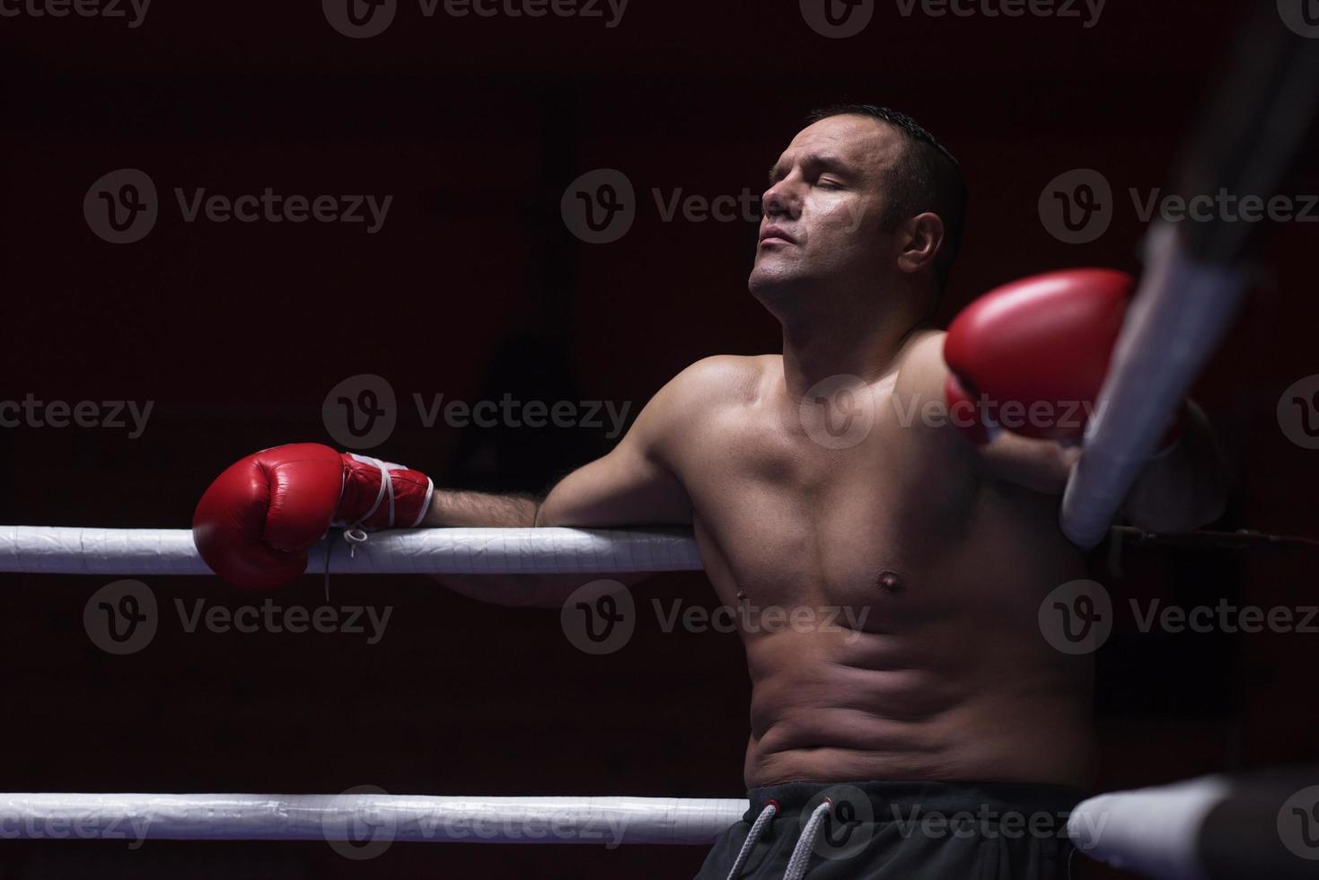 kick boxer resting on the ropes in the corner photo