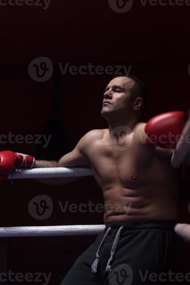 kick boxer resting on the ropes in the corner photo