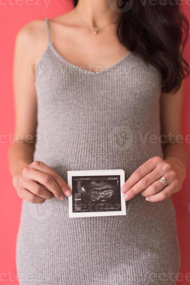 happy pregnant woman showing ultrasound picture photo