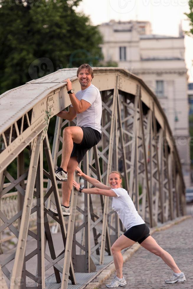 couple warming up and stretching before jogging photo