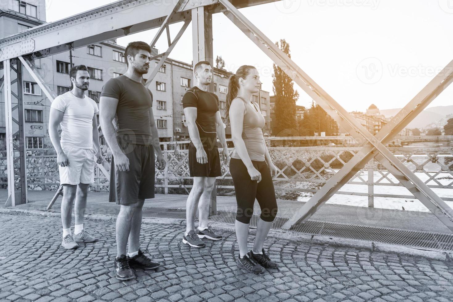 group of young people jogging across the bridge photo