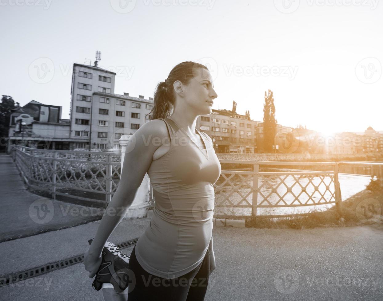 mujer corriendo por el puente en la mañana soleada foto