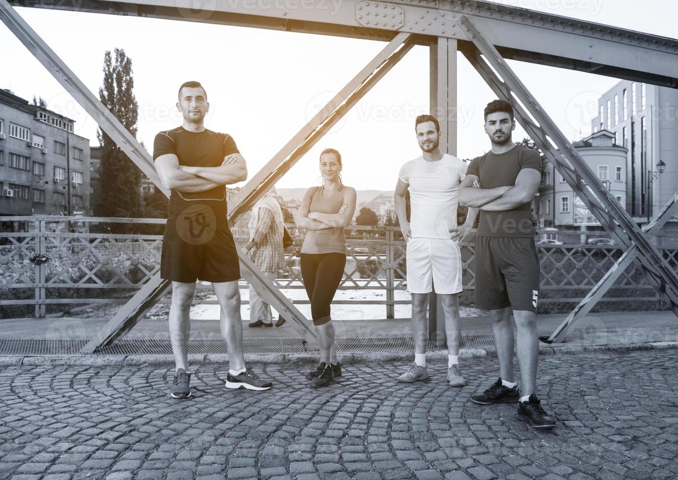 group of young people jogging across the bridge photo