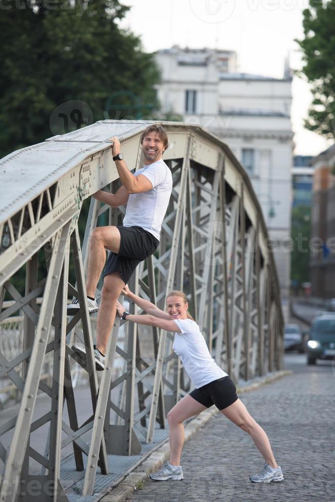 couple warming up and stretching before jogging photo