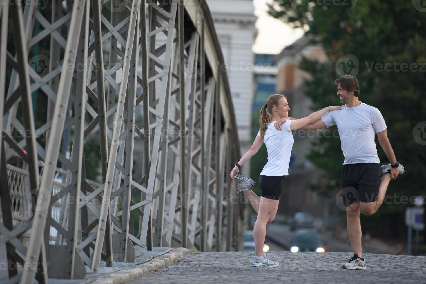 couple warming up and stretching before jogging photo