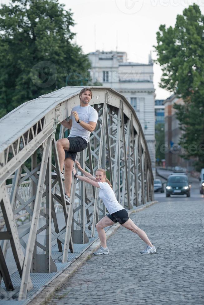 couple warming up and stretching before jogging photo