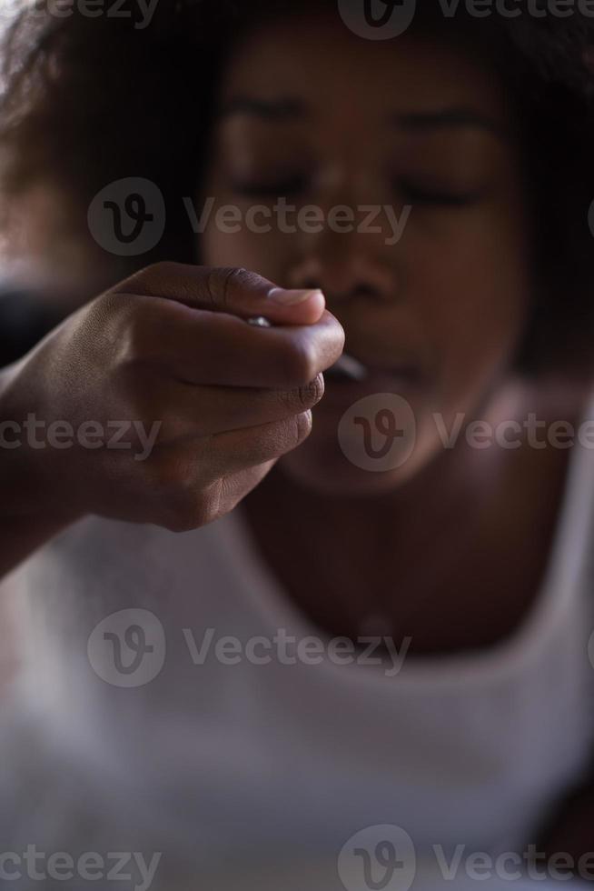 a young African American woman eating pasta photo