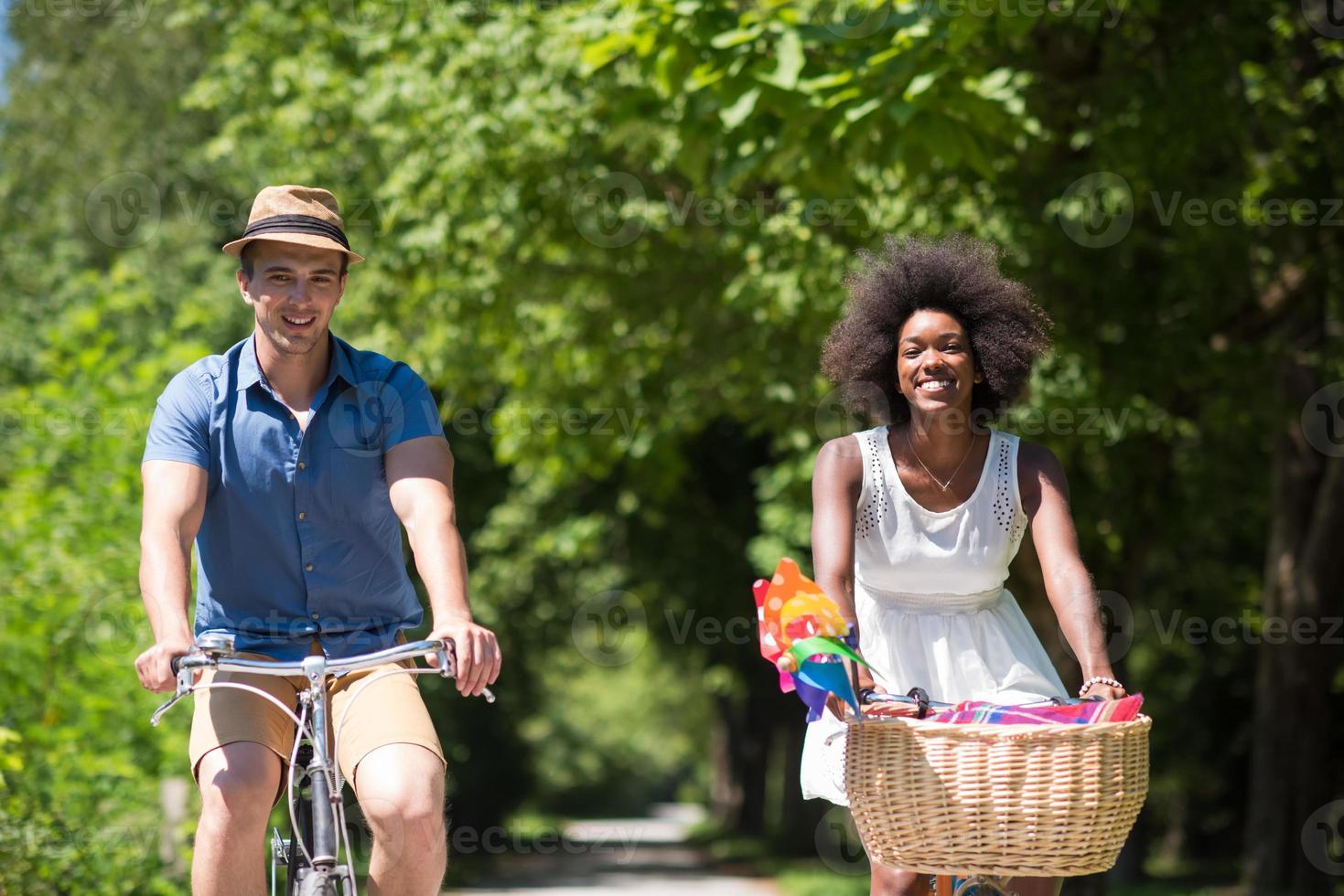 joven pareja multiétnica dando un paseo en bicicleta en la naturaleza foto