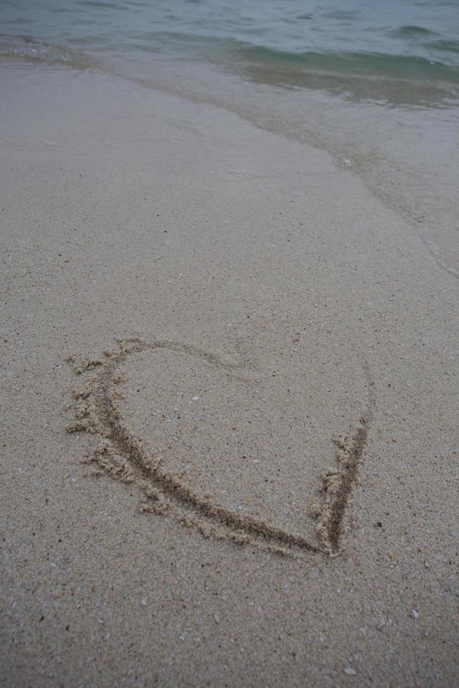 hearts drawn on the sand of a beach photo