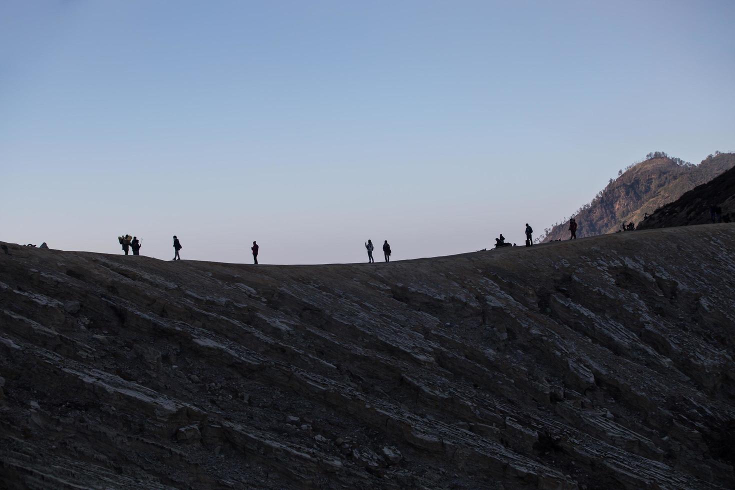 hiking tourists enjoying the sunrise view at Java Indonesia of Mount Ijen photo