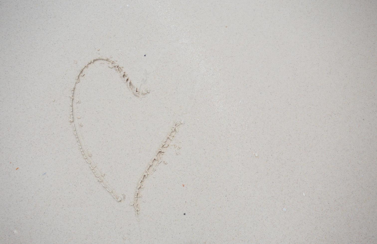 corazones dibujados en la arena de una playa foto