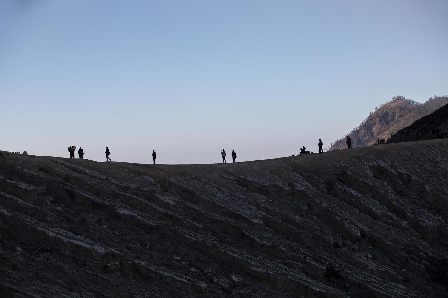 senderismo turistas disfrutando de la vista del amanecer en java indonesia del monte ijen foto