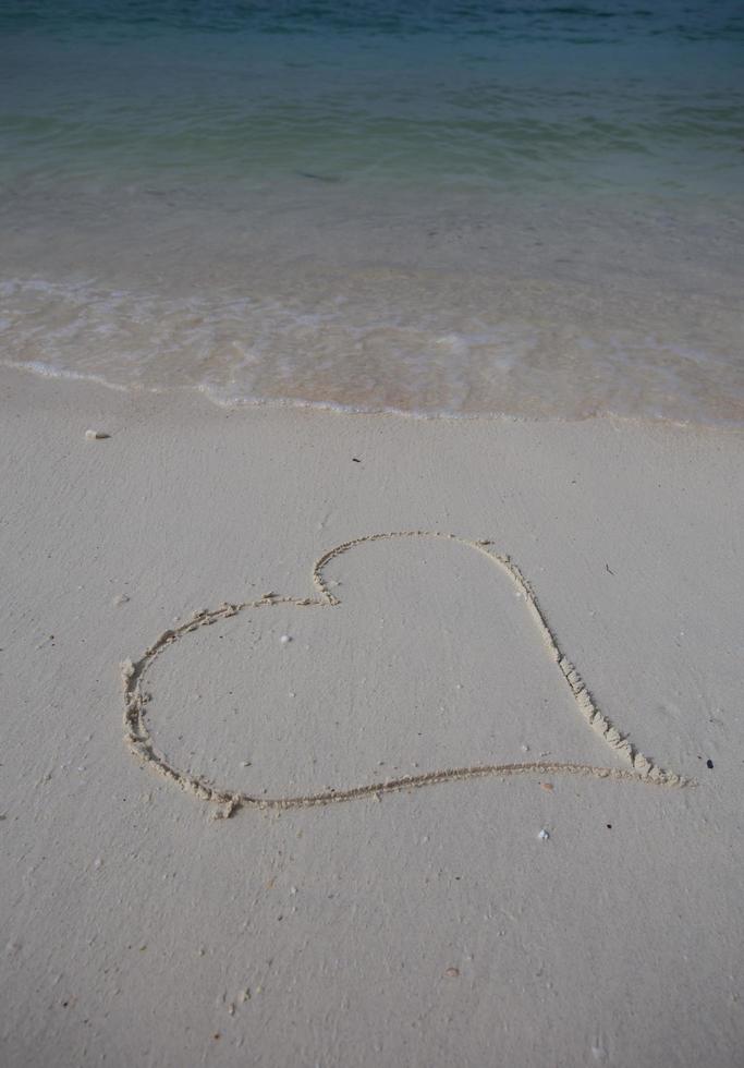 hearts drawn on the sand of a beach photo