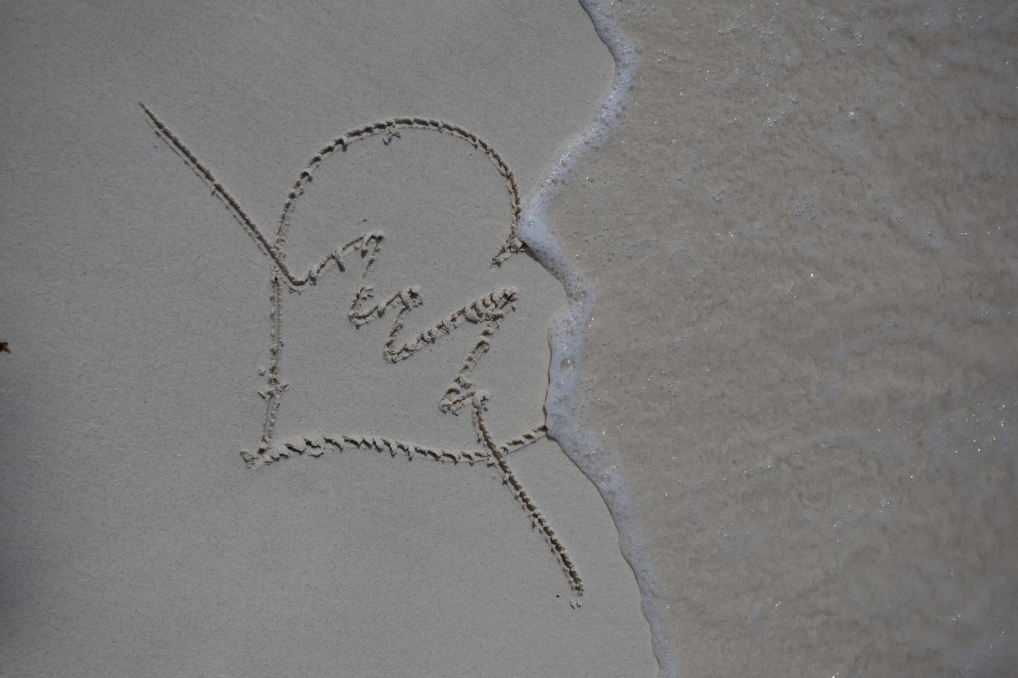 hearts drawn on the sand of a beach photo