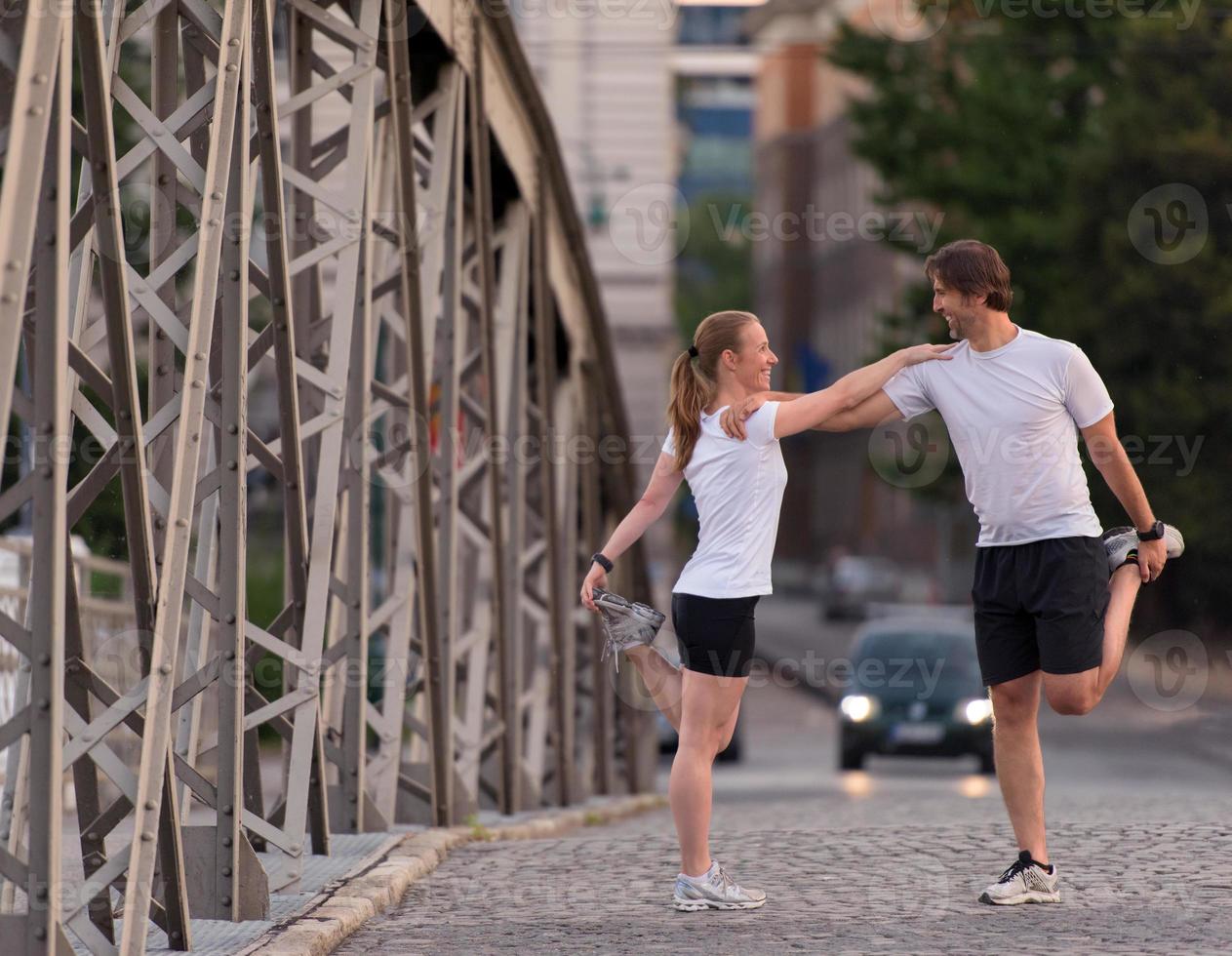 couple warming up and stretching before jogging photo