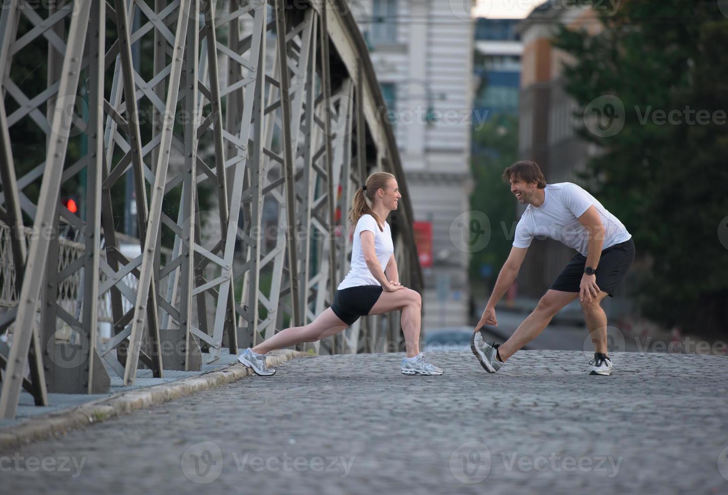 couple warming up and stretching before jogging photo