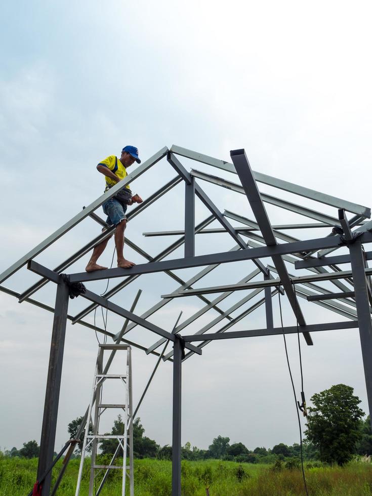 CHONBURI, THAILAND - Oct 12, 2016 Unidentified man walk and work on the steel frame of the house is under construction without protective equipment. photo