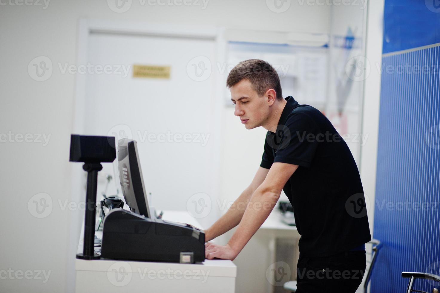 vendedor hombre consultor profesional de telefonía móvil en tienda de tecnología o tienda trabaja en el cajero. foto