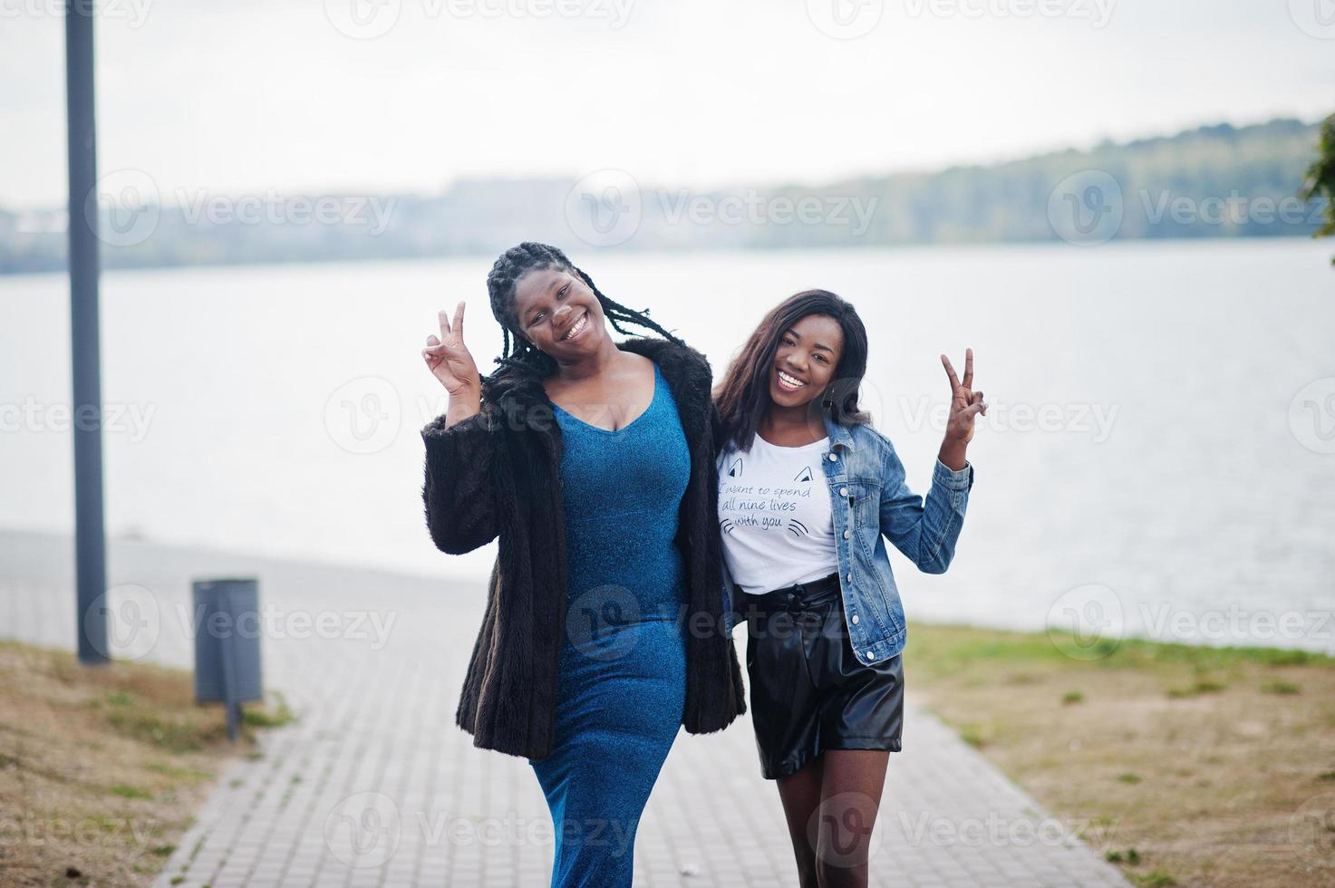 Two african american dark skinned friends female. One of them plus size model, second slim. Having fun and spending time together. photo
