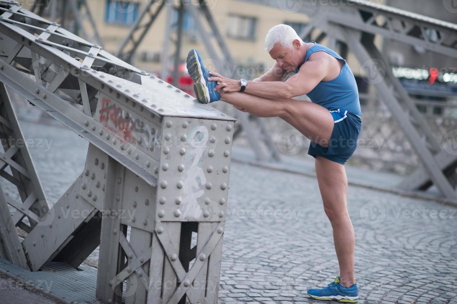 handsome man stretching before jogging photo