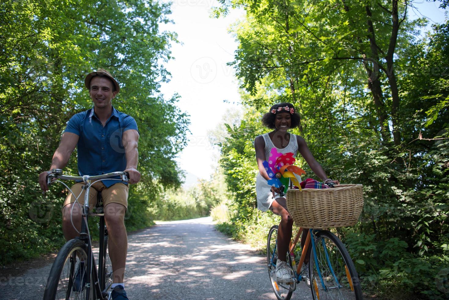 Young multiethnic couple having a bike ride in nature photo