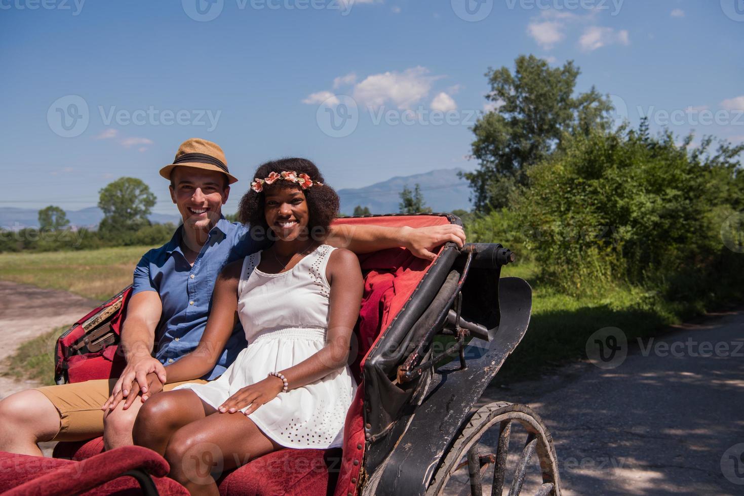 multiethnic couple sitting in a horse carriage photo