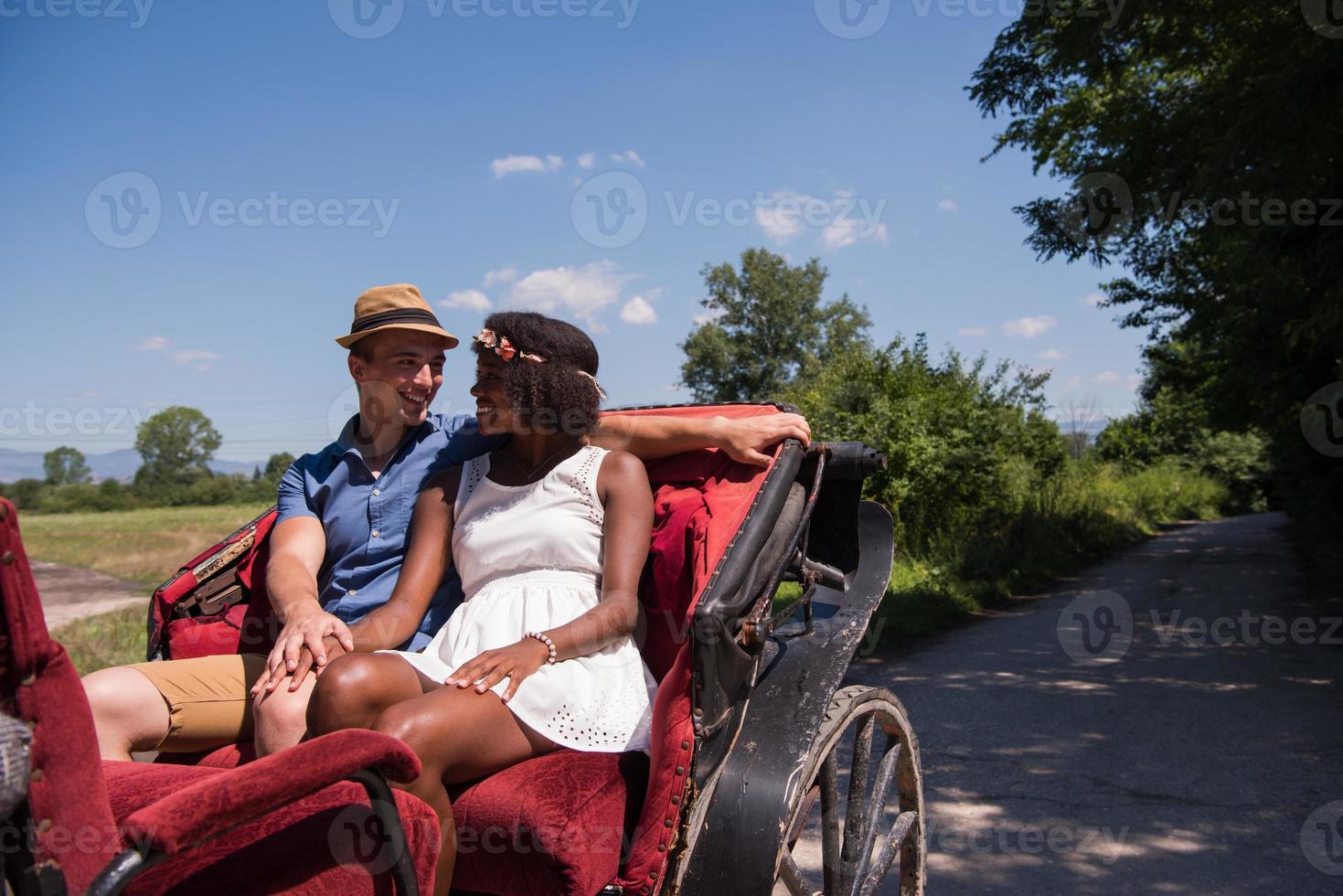 multiethnic couple sitting in a horse carriage photo