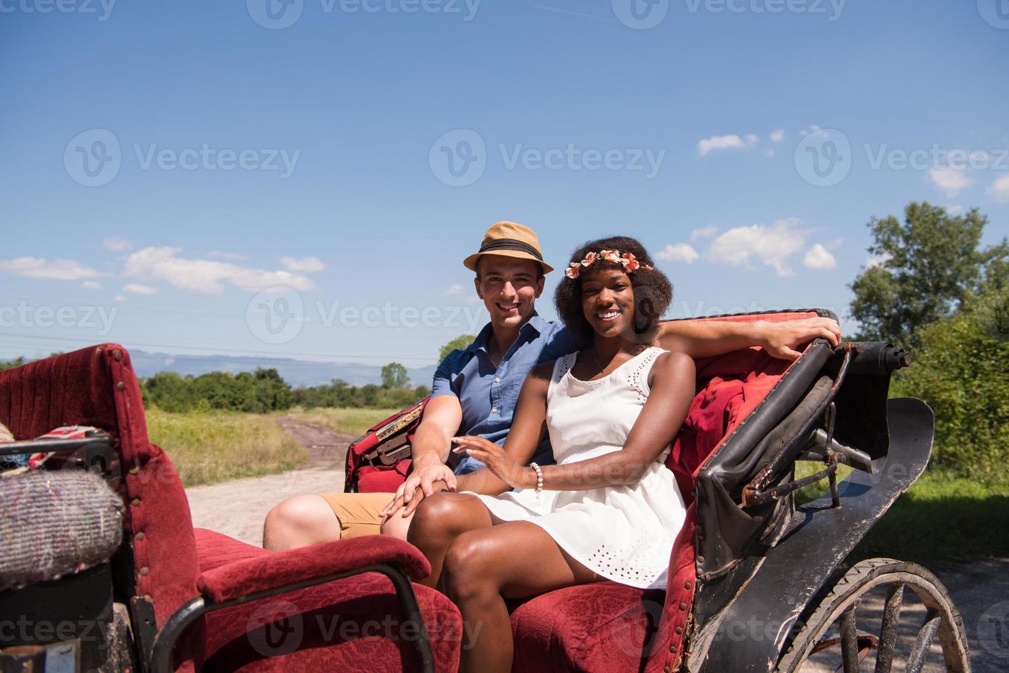 multiethnic couple sitting in a horse carriage photo