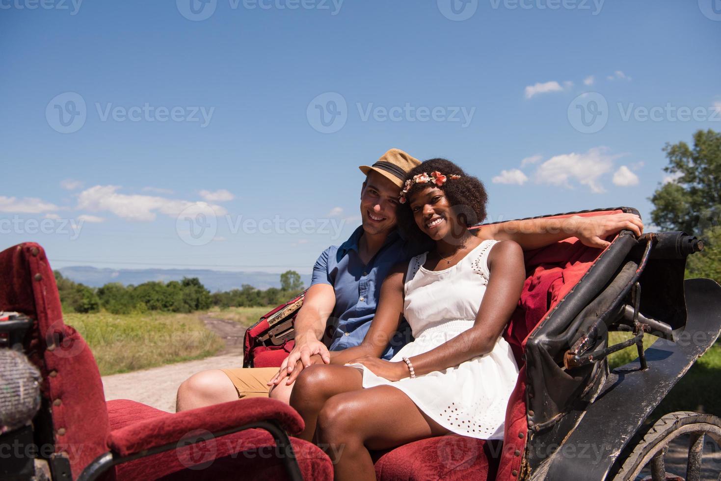 multiethnic couple sitting in a horse carriage photo