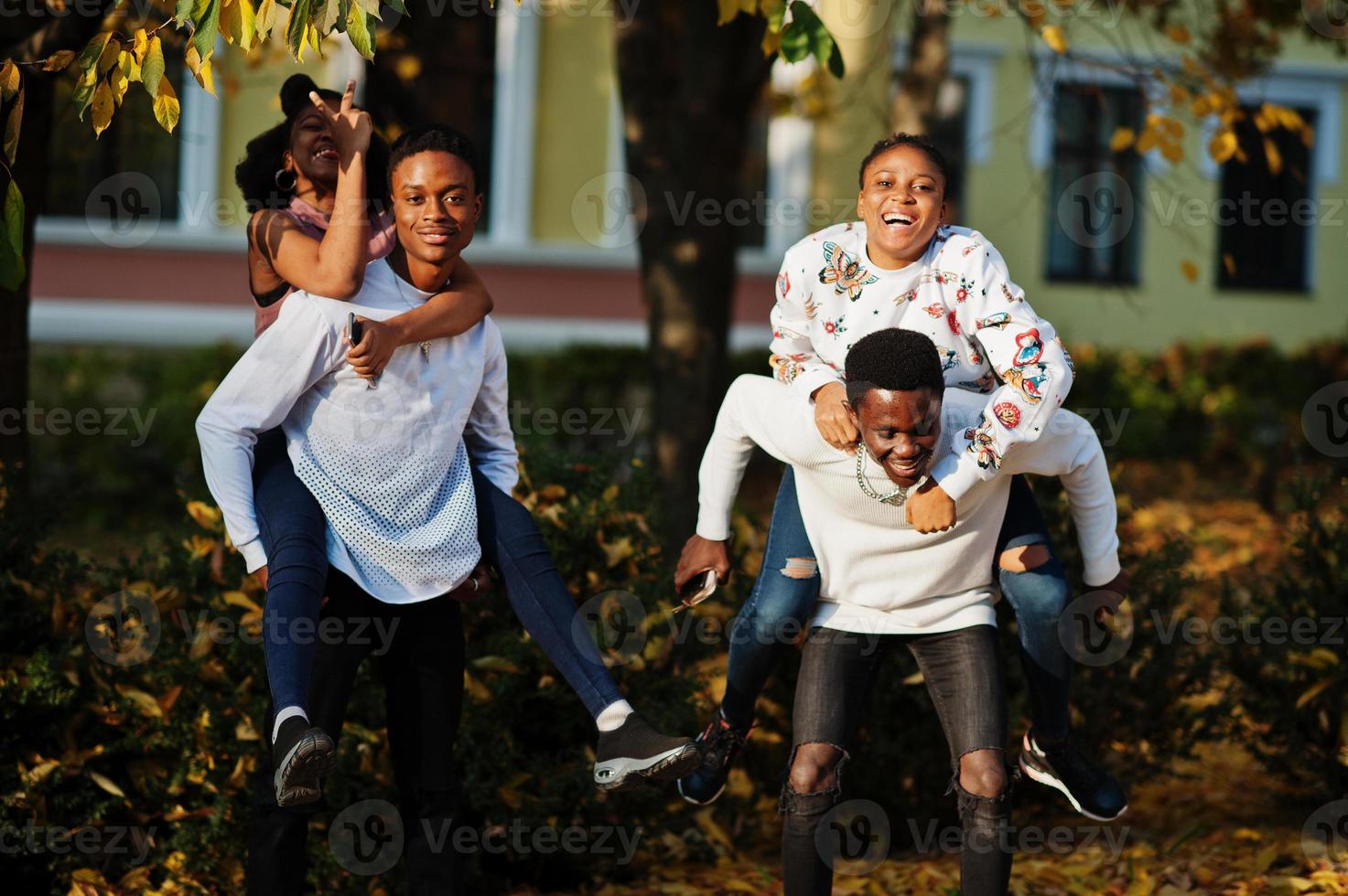 Four african friends walking the streets of an ancient city at autumn sunny day. photo