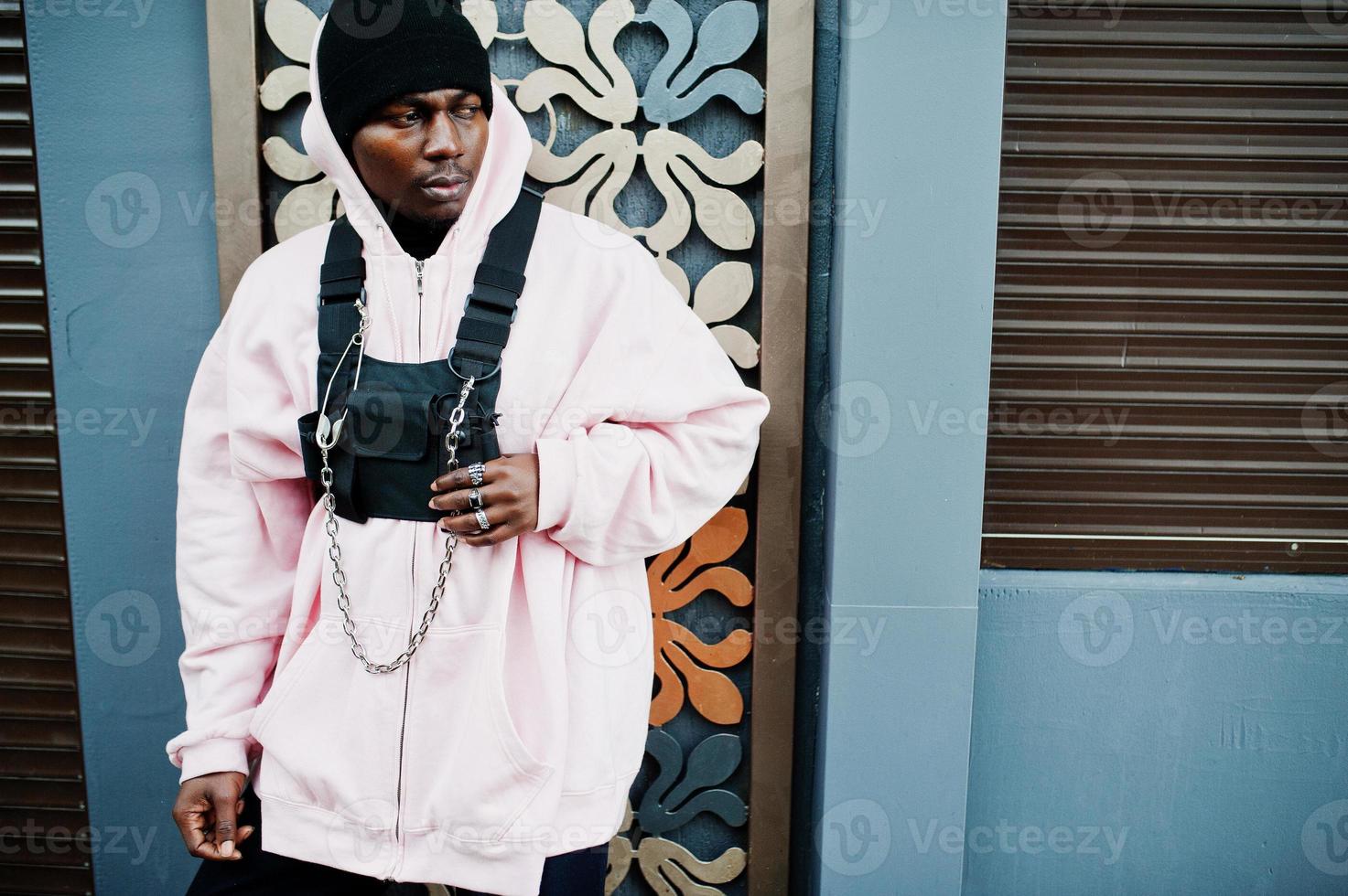 Stylish urban style african american man in pink hoodie posed. Afro rapper guy. photo