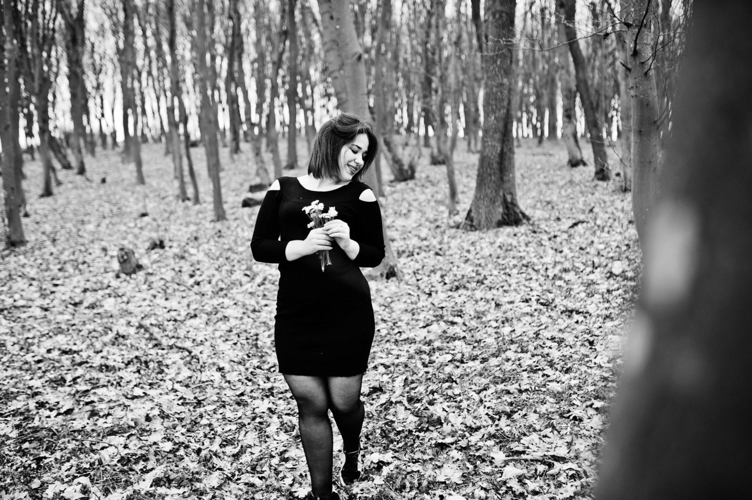 Portrait of brunette girl in black dress at spring wood. photo