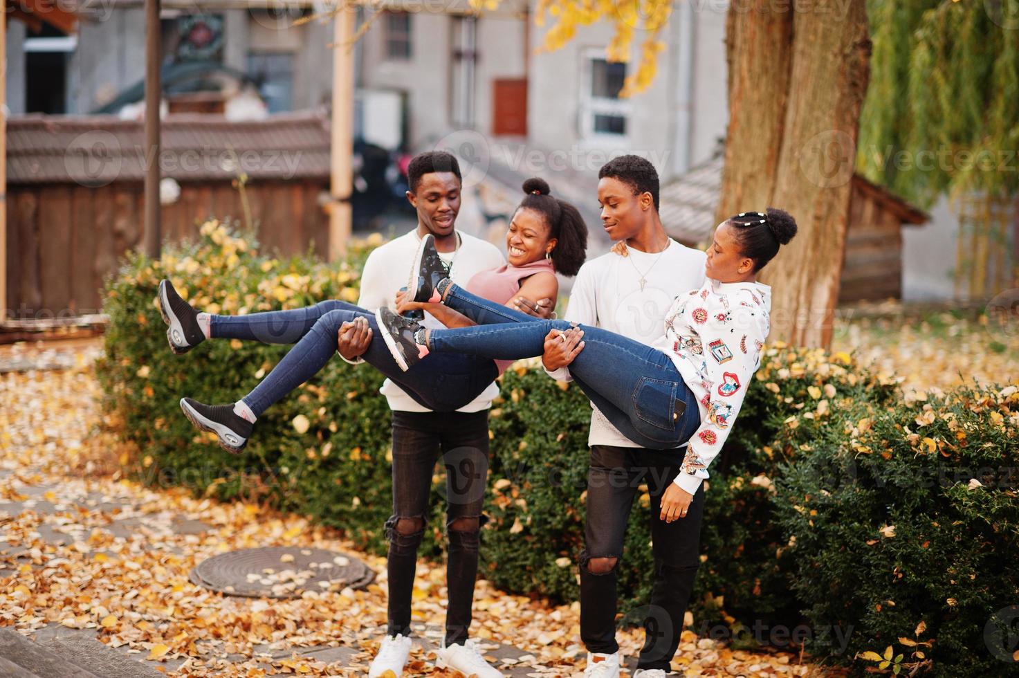 Four african friends walking the streets of an ancient city at autumn sunny day. photo