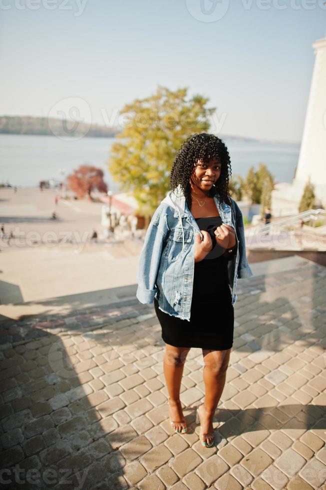 Stylish trendy afro france curly woman posed at autumn day in jeans jacket. Black african female model. photo