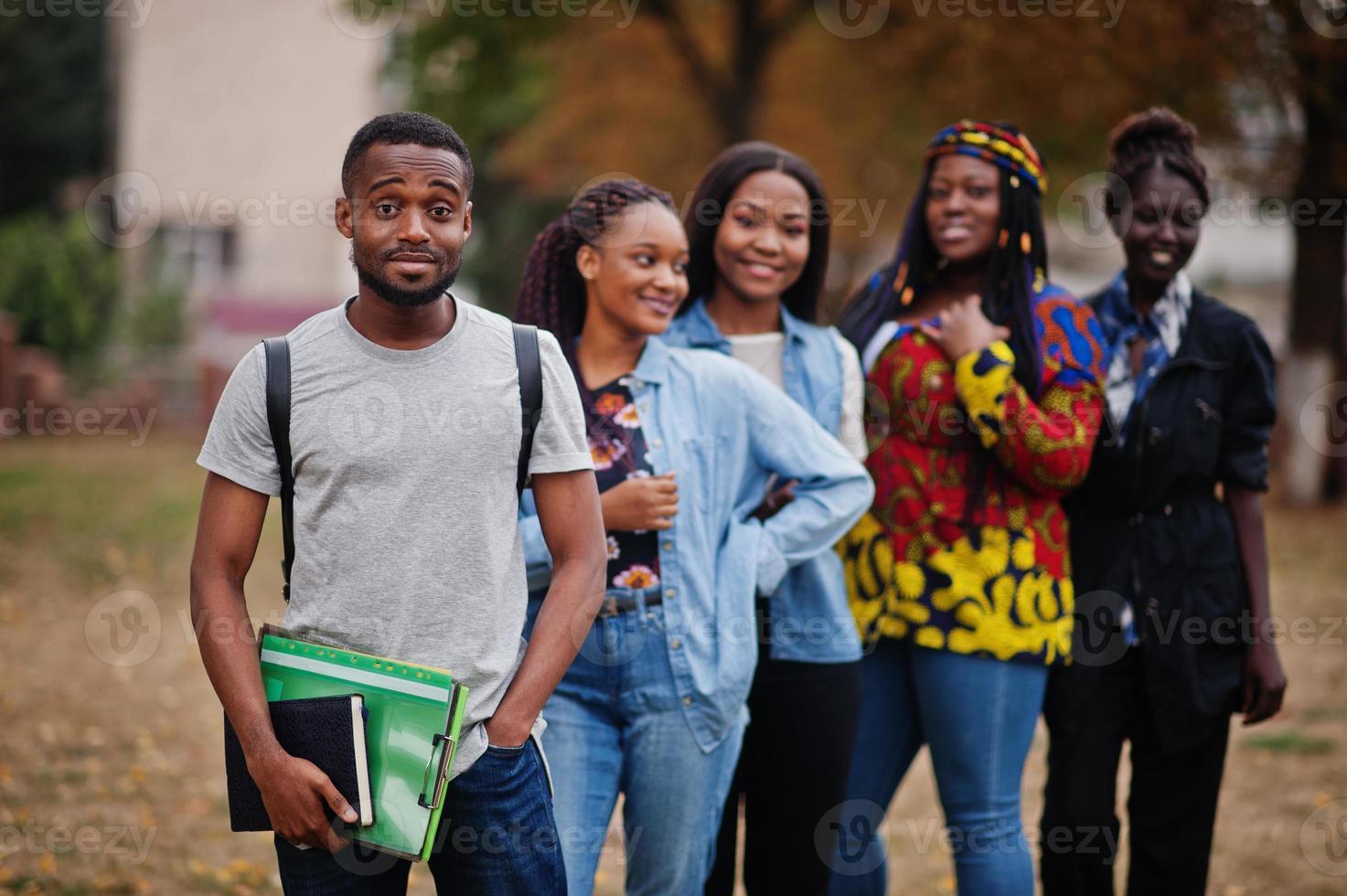 fila de estudiantes universitarios africanos del grupo cinco que pasan tiempo juntos en el campus en el patio de la universidad. amigos negros afro estudiando. tema de la educación foto